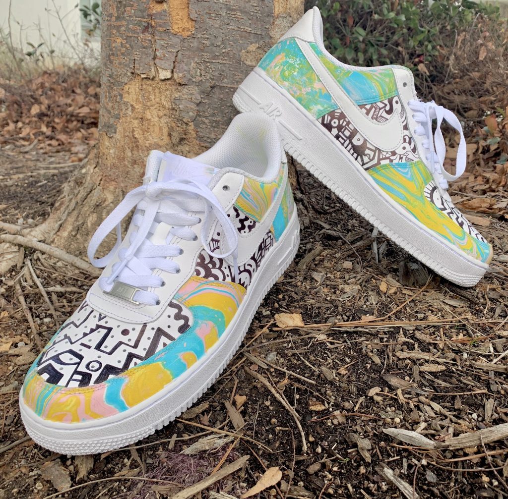 Colorful hand-painted sneakers on ground